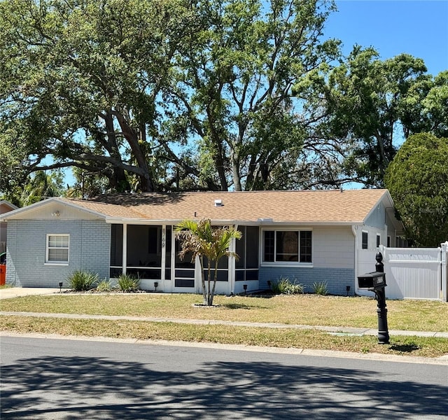 8766 91st St, Seminole, FL 33777 - ranch-style house featuring a sunroom, brick siding, and roof with shingles