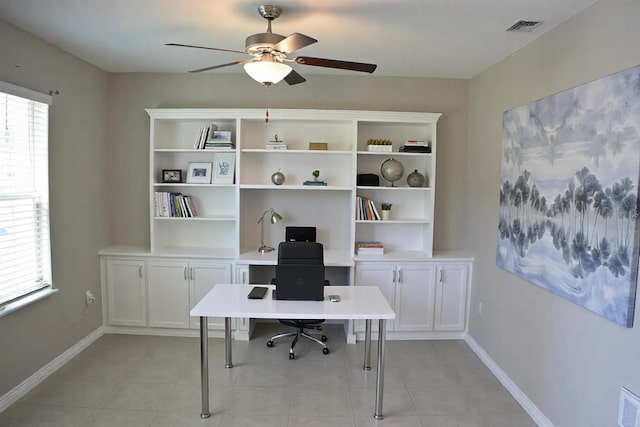 home office featuring plenty of natural light, a ceiling fan, visible vents, and baseboards