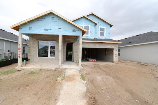 property under construction with an attached garage, concrete block siding, and concrete driveway