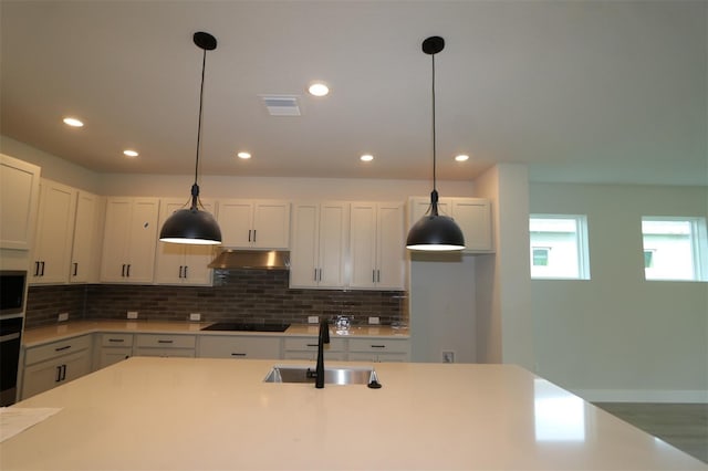 11884 Richmond Trl, Parrish, FL 34219 - kitchen featuring under cabinet range hood, black electric cooktop, decorative backsplash, light countertops, and recessed lighting