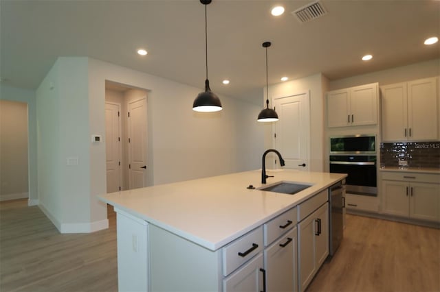 11884 Richmond Trl, Parrish, FL 34219 - kitchen featuring appliances with stainless steel finishes, light wood-style flooring, recessed lighting, decorative light fixtures, and light countertops