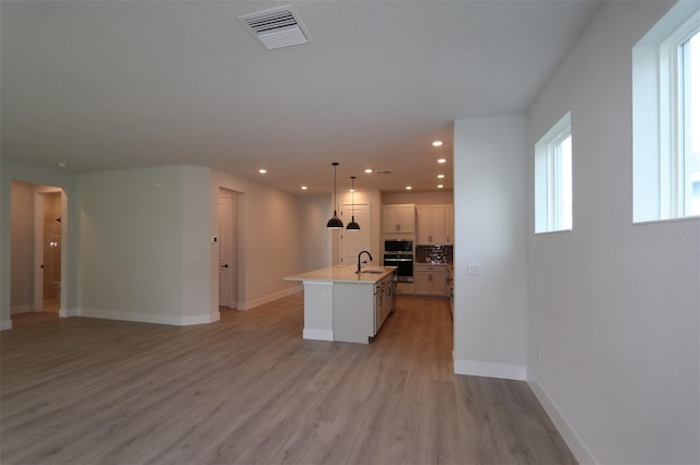 11884 Richmond Trl, Parrish, FL 34219 - kitchen featuring a kitchen island with sink, open floor plan, light wood-style flooring, recessed lighting, and light countertops