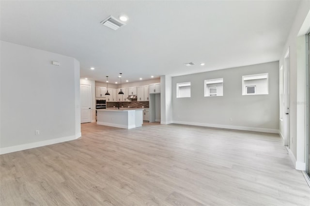 11884 Richmond Trl, Parrish, FL 34219 - unfurnished living room with recessed lighting and light wood-style floors