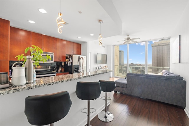 777 N Ashley Dr Unit 2610, Tampa, FL 33602 - kitchen featuring tasteful backsplash, a wall of windows, dark wood-style floors, pendant lighting, and appliances with stainless steel finishes