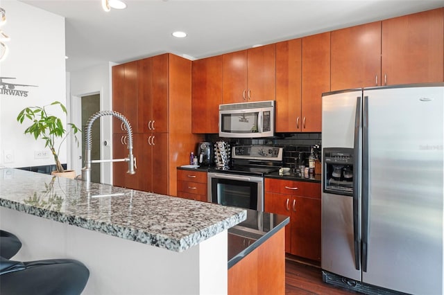 777 N Ashley Dr Unit 2610, Tampa, FL 33602 - kitchen with tasteful backsplash, a kitchen breakfast bar, a peninsula, stainless steel appliances, and dark wood-style flooring