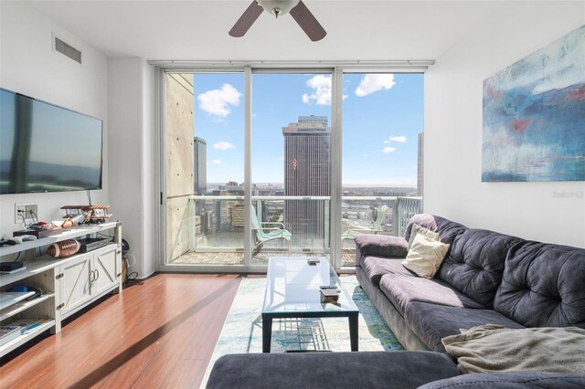 777 N Ashley Dr Unit 2610, Tampa, FL 33602 - living area with visible vents, a city view, a wall of windows, wood finished floors, and a ceiling fan
