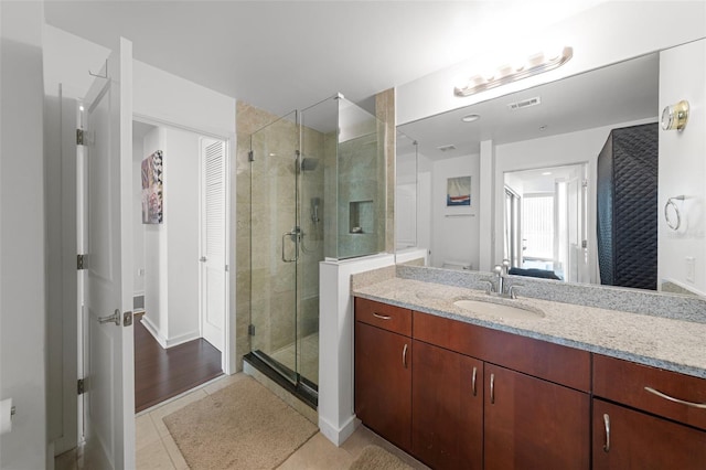 777 N Ashley Dr Unit 2610, Tampa, FL 33602 - bathroom featuring tile patterned flooring, vanity, a stall shower, ensuite bath, and visible vents