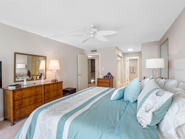 bedroom featuring a ceiling fan, carpet flooring, a textured ceiling, and visible vents