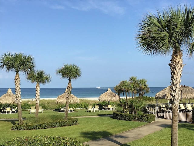 surrounding community with fence, a water view, and a yard