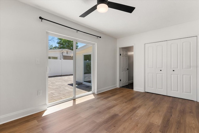 331 Barbara Cir, Belleair, FL 33756 - unfurnished bedroom featuring access to outside, wood finished floors, baseboards, a closet, and a ceiling fan