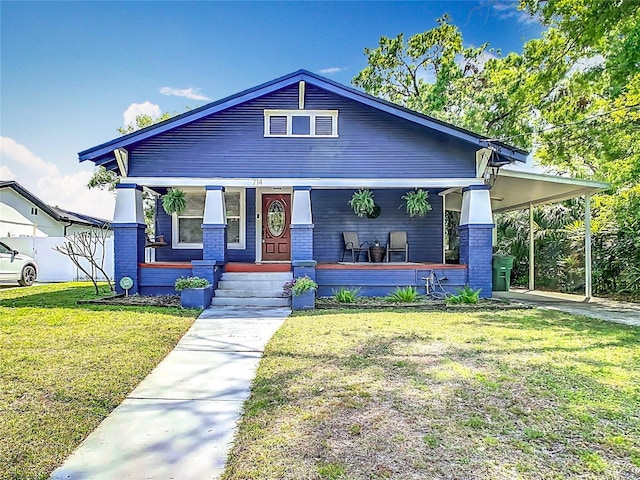 view of front of property featuring a carport, a front yard, and covered porch
