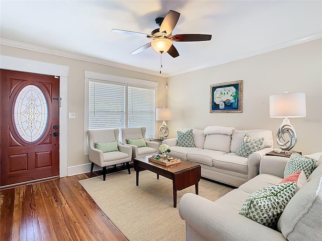 living room with ornamental molding, baseboards, ceiling fan, and wood finished floors