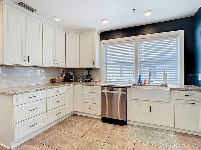kitchen with backsplash, a sink, white cabinetry, stainless steel dishwasher, and visible vents