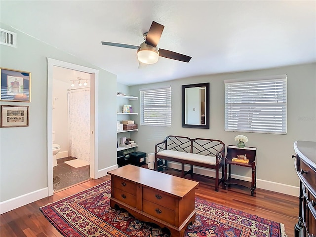 sitting room with baseboards, visible vents, a ceiling fan, and wood finished floors