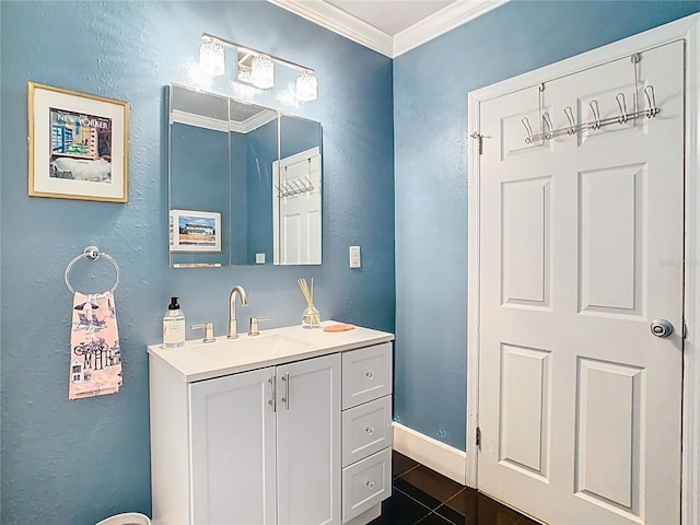 bathroom with vanity, a textured wall, crown molding, and baseboards