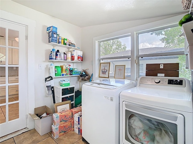 laundry area featuring light tile patterned flooring, washing machine and dryer, and laundry area