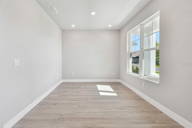 unfurnished room featuring baseboards, light wood-style flooring, visible vents, and recessed lighting