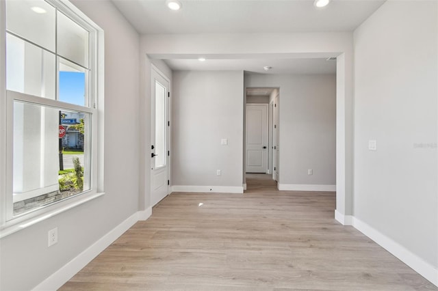 empty room featuring recessed lighting, a healthy amount of sunlight, and baseboards
