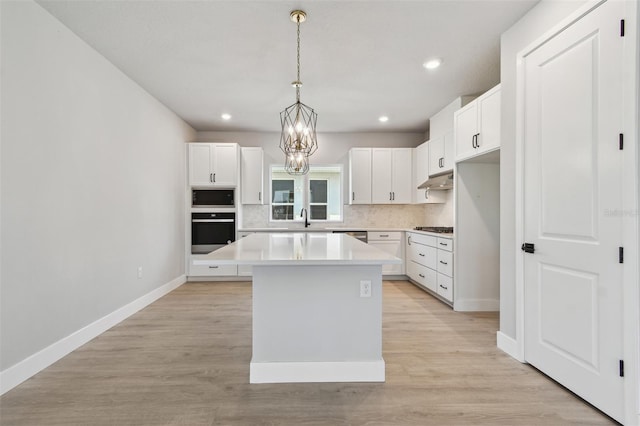 kitchen featuring built in microwave, gas cooktop, oven, backsplash, and baseboards