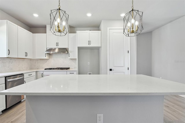 kitchen with stainless steel appliances, light wood-type flooring, under cabinet range hood, and an inviting chandelier