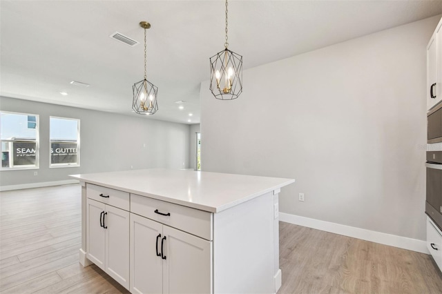 kitchen featuring baseboards, light countertops, visible vents, and light wood-style flooring