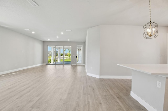 unfurnished living room featuring visible vents, baseboards, and light wood-style floors