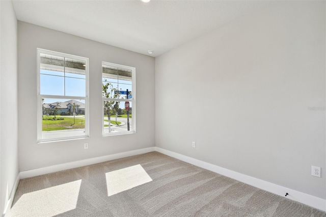 spare room featuring baseboards and carpet