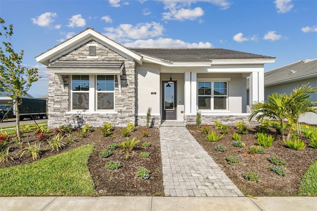 view of front of house with a porch, stone siding, and stucco siding