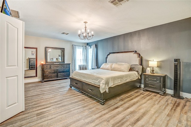 16755 Sunrise Vista Dr, Clermont, FL 34714 - bedroom featuring a notable chandelier, baseboards, light wood-style floors, and visible vents