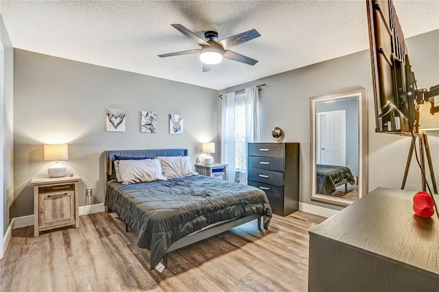 16755 Sunrise Vista Dr, Clermont, FL 34714 - bedroom with baseboards, light wood-style floors, and a textured ceiling