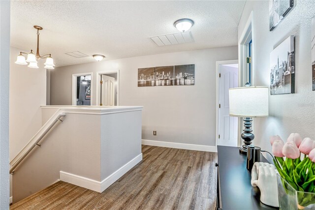 16755 Sunrise Vista Dr, Clermont, FL 34714 - hall with baseboards, a textured ceiling, an upstairs landing, and wood finished floors