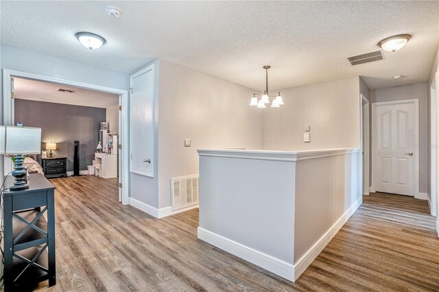 16755 Sunrise Vista Dr, Clermont, FL 34714 - hall featuring baseboards, visible vents, an inviting chandelier, and wood finished floors