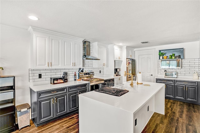16755 Sunrise Vista Dr, Clermont, FL 34714 - kitchen featuring wall chimney range hood, dark wood-style flooring, white cabinetry, and stainless steel appliances