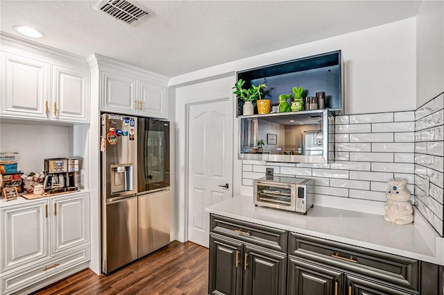 16755 Sunrise Vista Dr, Clermont, FL 34714 - kitchen featuring light countertops, stainless steel fridge with ice dispenser, white cabinetry, dark wood finished floors, and visible vents