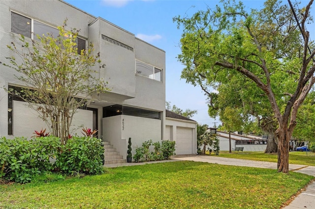 4522 W N B St, Tampa, FL 33609 - view of front of home with a front yard, concrete driveway, stucco siding, and an attached garage