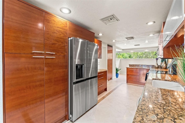 4522 W N B St, Tampa, FL 33609 - kitchen with visible vents, modern cabinets, light stone countertops, appliances with stainless steel finishes, and brown cabinetry