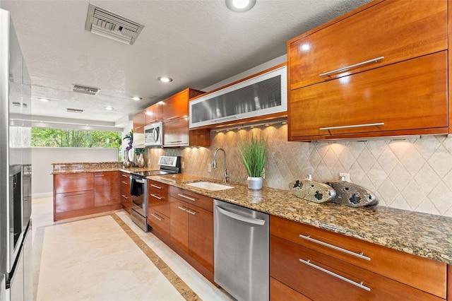 4522 W N B St, Tampa, FL 33609 - kitchen featuring a sink, appliances with stainless steel finishes, brown cabinetry, and visible vents