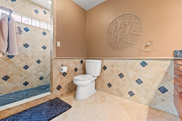 4522 W N B St, Tampa, FL 33609 - full bath featuring tile walls, a tile shower, toilet, tile patterned floors, and wainscoting