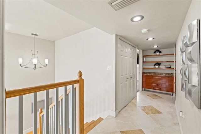 4522 W N B St, Tampa, FL 33609 - hallway with visible vents, baseboards, a chandelier, and a textured ceiling