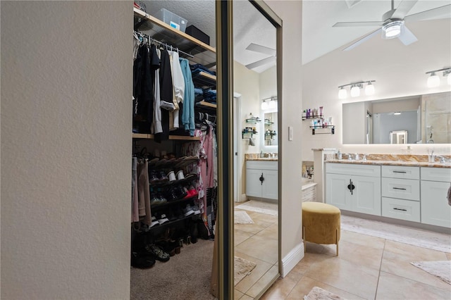 walk in closet with ceiling fan, a sink, and light tile patterned floors