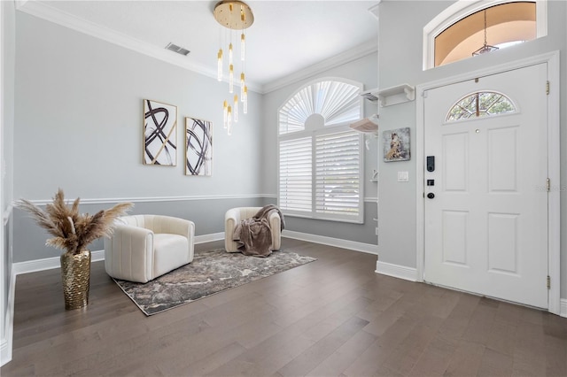 entryway with a healthy amount of sunlight, baseboards, ornamental molding, and wood finished floors