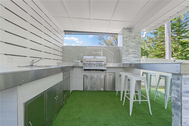 view of patio / terrace with grilling area, an outdoor kitchen, a sink, and outdoor wet bar
