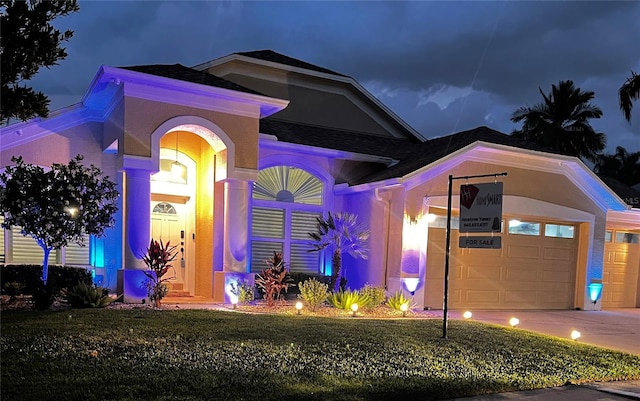 view of front of property featuring concrete driveway and an attached garage