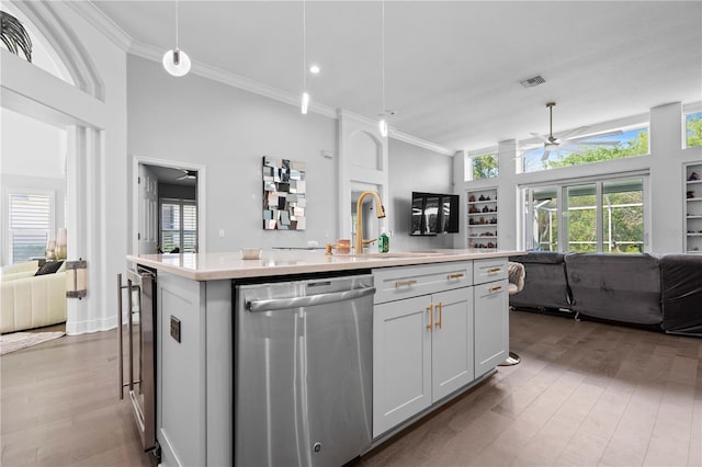 kitchen featuring stainless steel dishwasher, a ceiling fan, open floor plan, and ornamental molding
