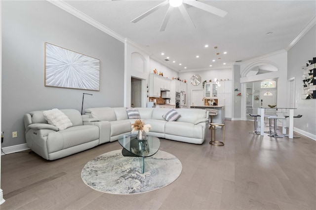 living room with crown molding, a ceiling fan, baseboards, and recessed lighting