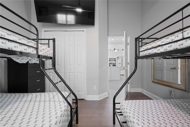 bedroom featuring baseboards, dark wood-style floors, and a closet