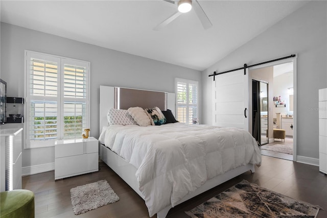 bedroom with baseboards, dark wood-type flooring, a barn door, a ceiling fan, and vaulted ceiling