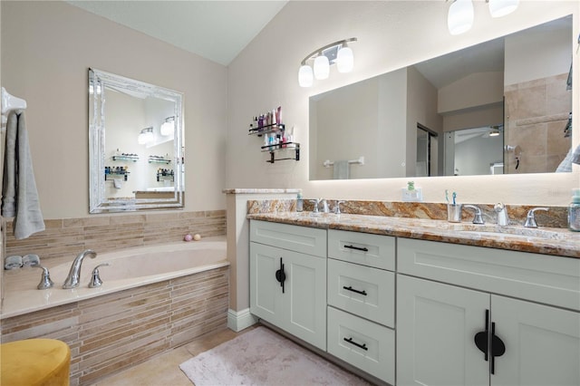 full bath with a sink, tile patterned floors, a garden tub, and double vanity
