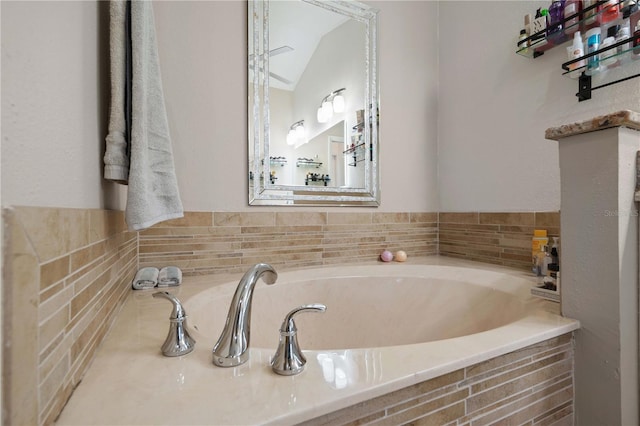 bathroom featuring lofted ceiling and a garden tub