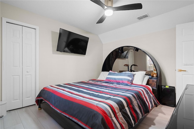 bedroom with a closet, a ceiling fan, lofted ceiling, and visible vents